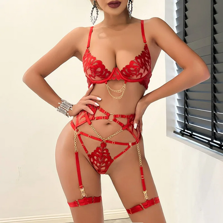 Model standing in red embroidered lingerie with garter straps and golden details